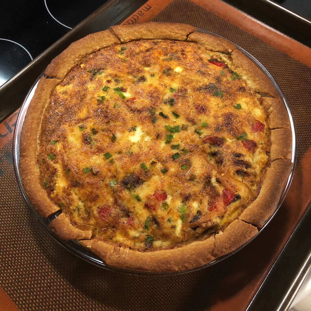 Meat Lover's Quiche baked until golden brown in a flaky all-butter pie crust with bacon, kielbasa, ham, cheese, and green onions.